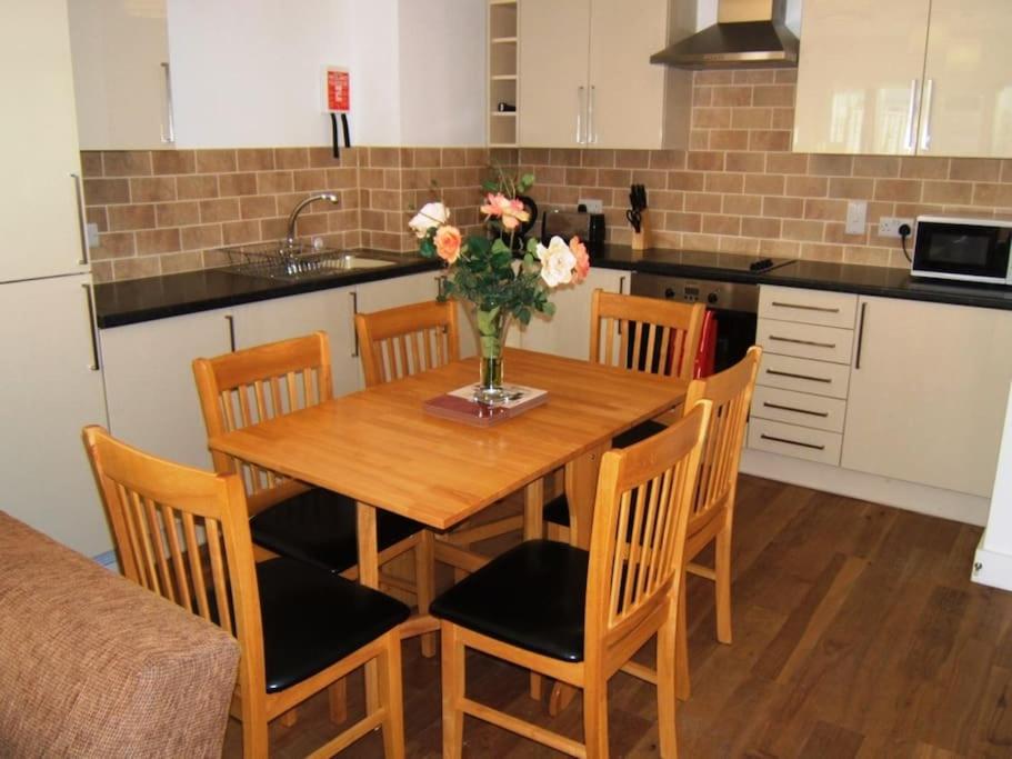 uma cozinha com uma mesa de madeira com um vaso de flores em BOURNECOAST: CLOSE TO SHOPS / SANDY BEACH -FM4034 em Bournemouth