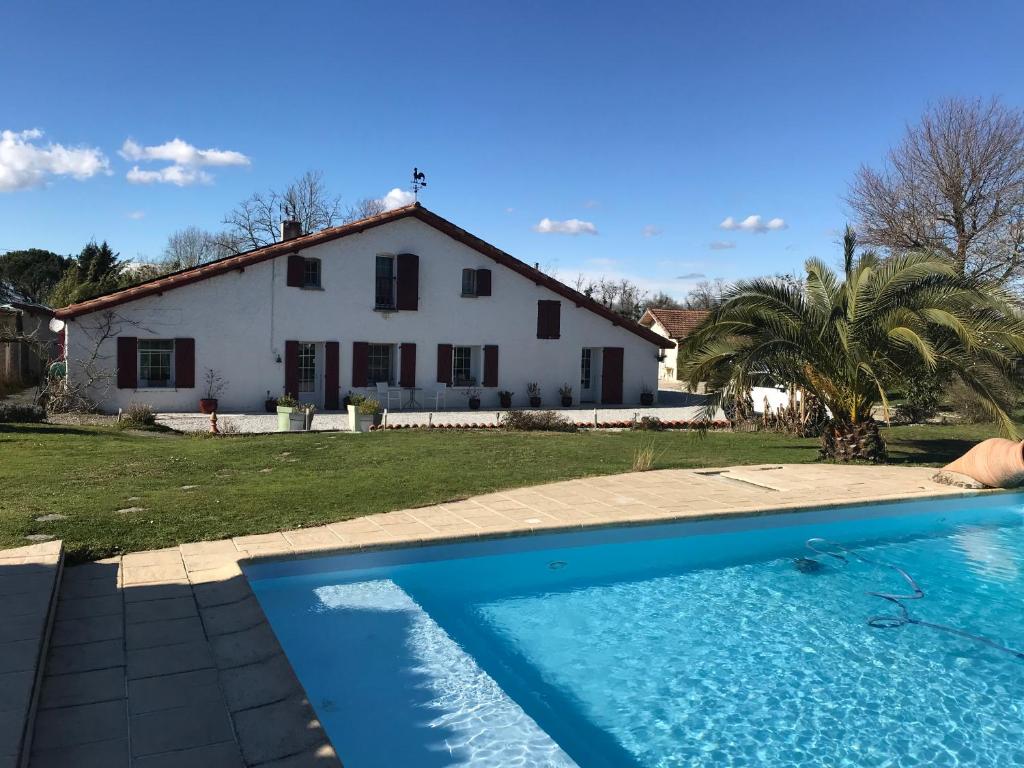 une maison et une piscine en face d'une maison dans l'établissement Gîte La Forge De Clermont, à Clermont