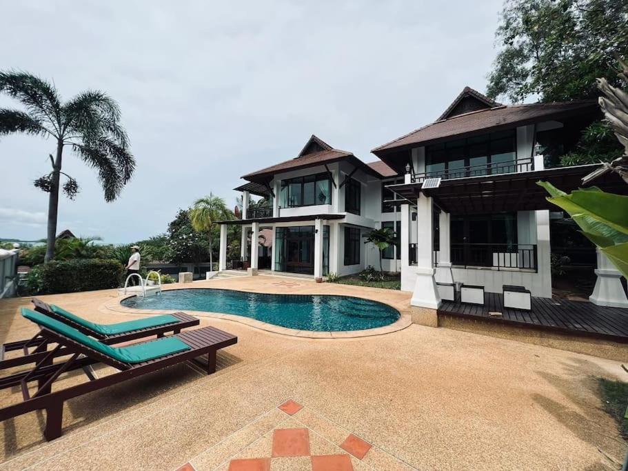 a house with a swimming pool in front of a house at villa vue mer in Amphoe Koksamui