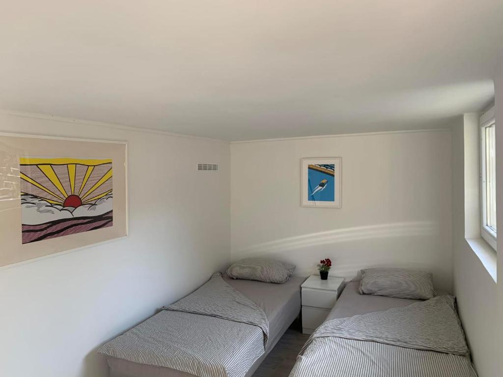 Duas camas num quarto com paredes brancas em Majos Lodge em Majosháza