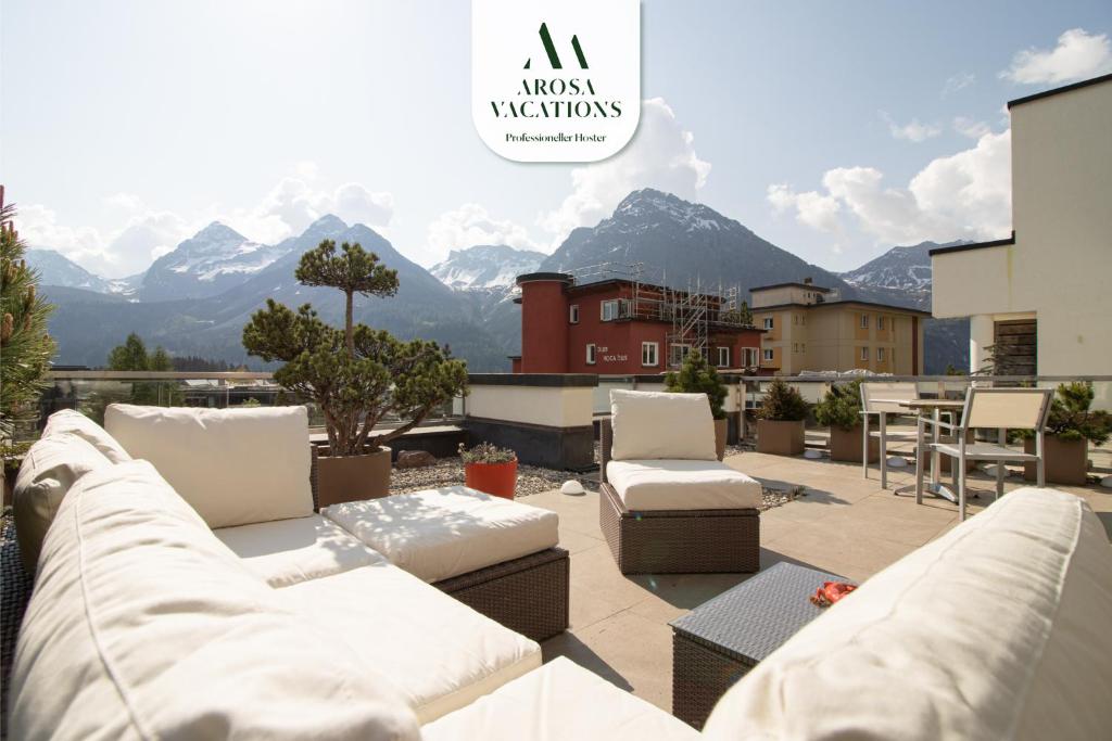 a patio with couches and a view of mountains at Galerie Obersee 3E in Arosa