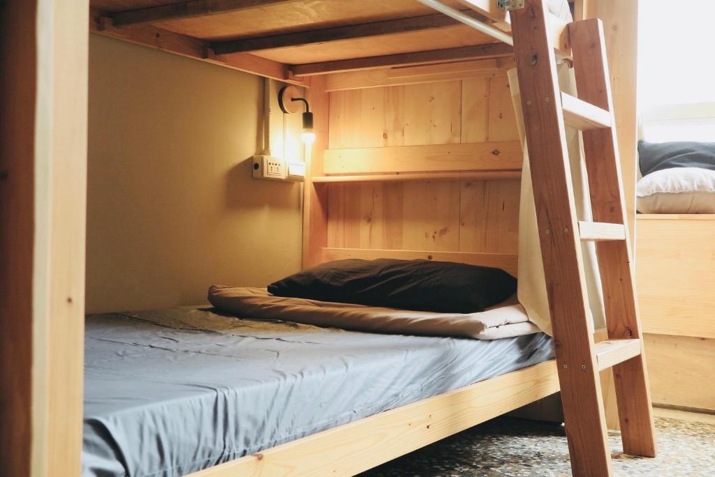 a bunk bed in a room with a ladder at Walk Home Hostel in Chiayi City