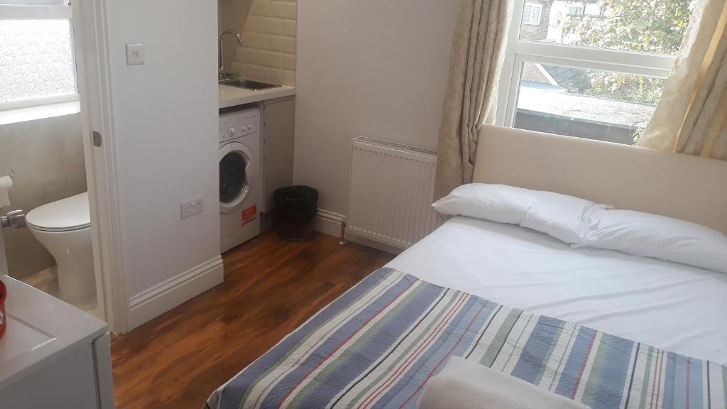- une petite chambre avec un lit et une fenêtre dans l'établissement Luxury studio flat, à Londres