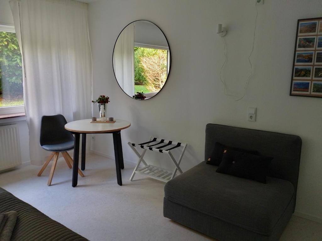 een woonkamer met een tafel en een spiegel bij Wald und Wiese in Kreuztal