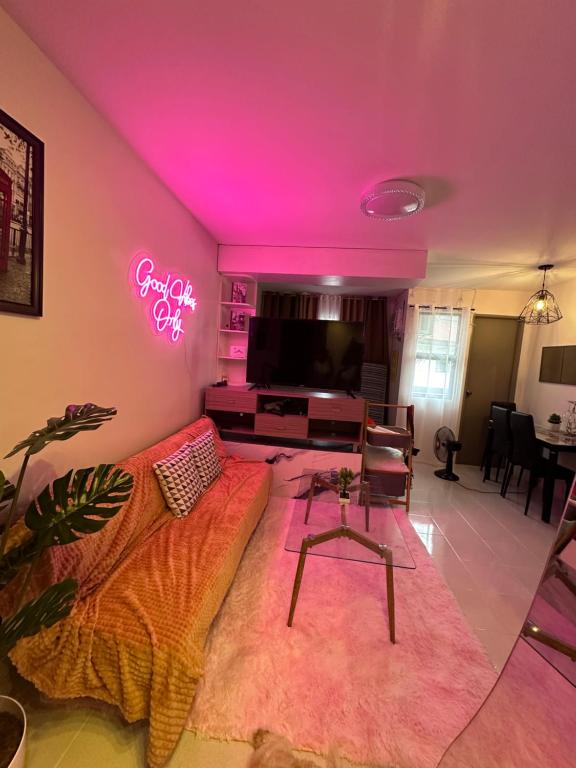 Santa Rosa的住宿－HM Cozy Place beside Enchanted Kingdom，带沙发和 ⁇ 虹灯标志的客厅
