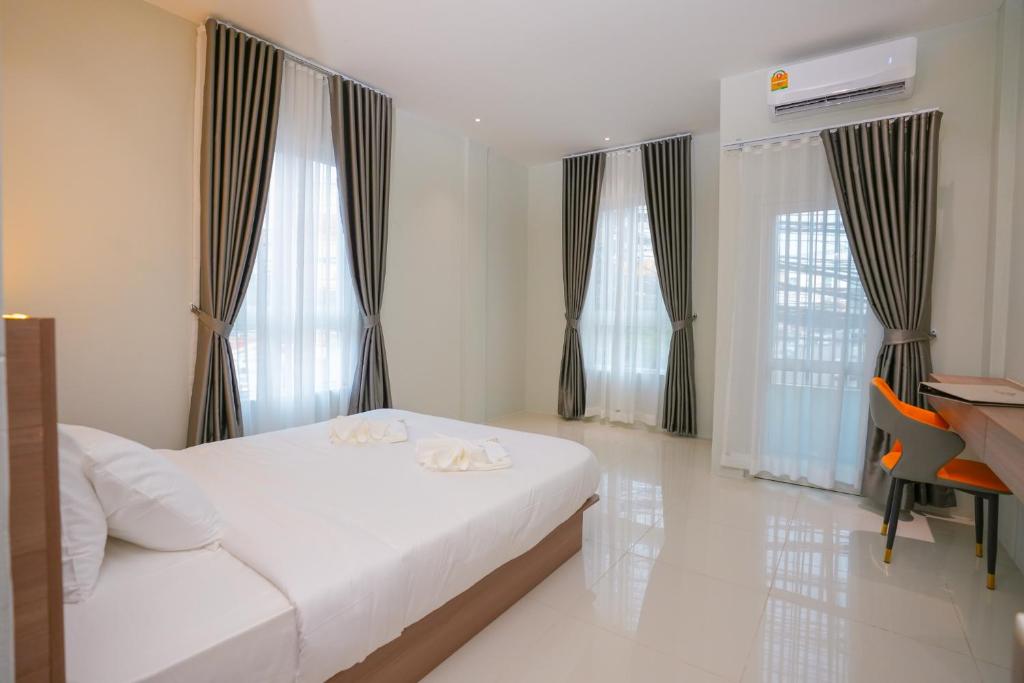 um quarto com uma cama, uma secretária e janelas em Athenee Hotel Vientiane em Vientiane