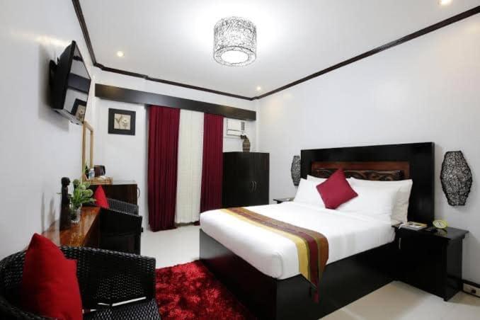 a hotel room with a bed and a chair at Coron Bancuang Mansion in Coron