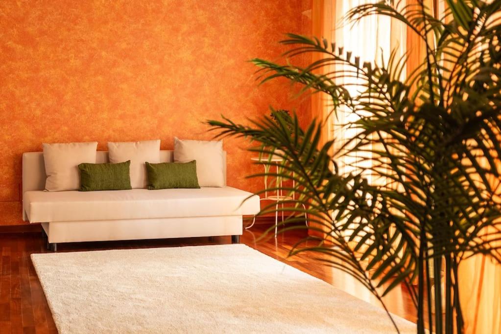 sala de estar con sofá blanco y planta en Attico vicino Milano, MXP, Rho Fiera, en Busto Arsizio