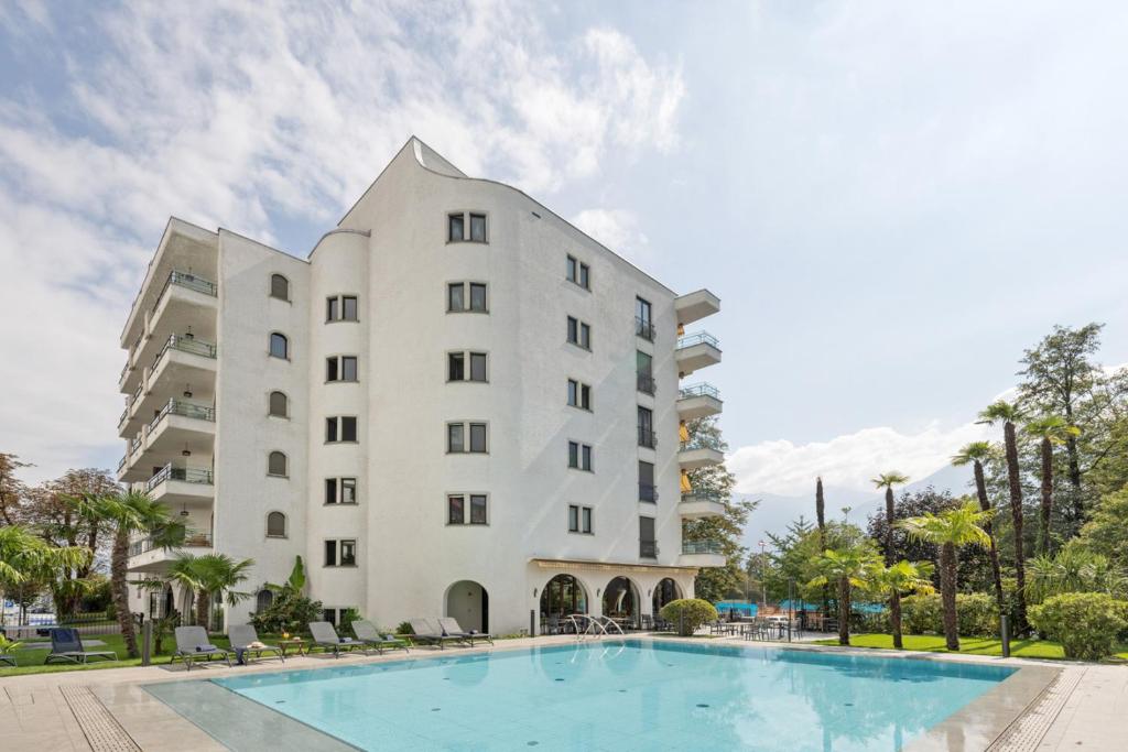 um hotel com piscina em frente a um edifício em Aparthotel Al Lago em Locarno