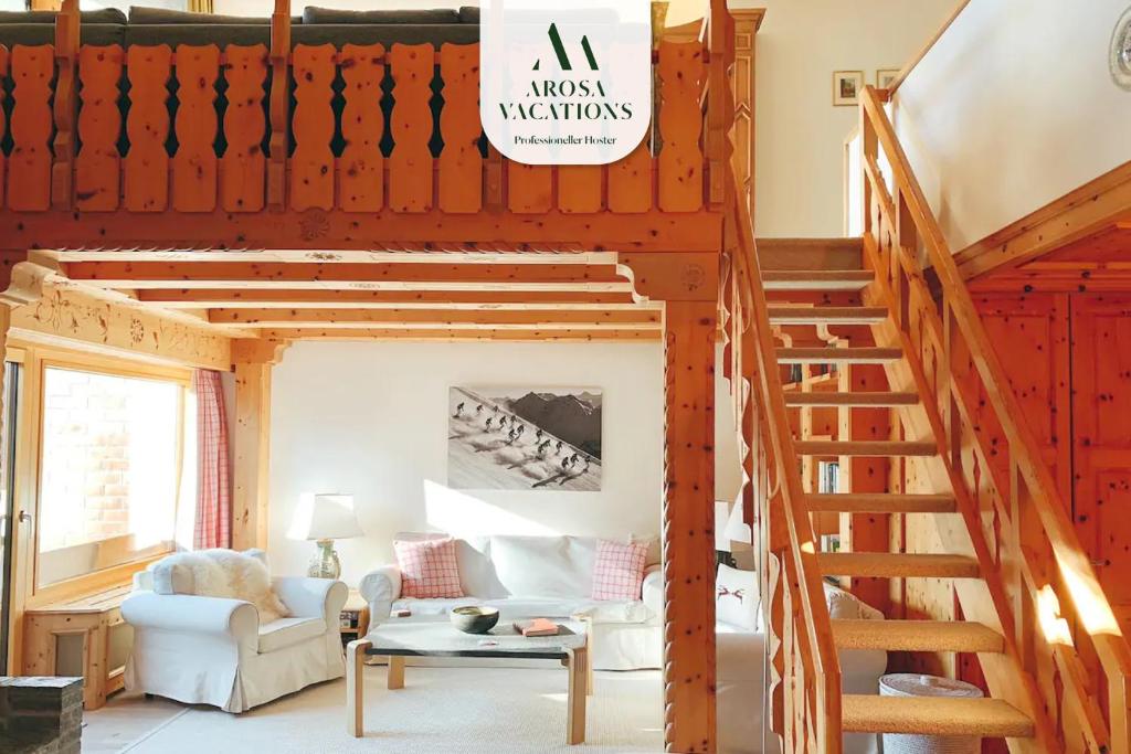 a living room with a loft bed with a staircase at Rehwiesa A33 in Arosa
