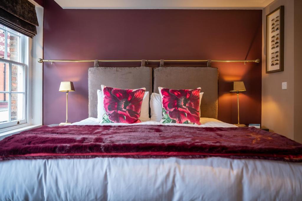 a bedroom with a large bed with red pillows at At Home in Shrewsbury