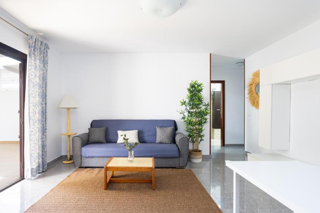 ein Wohnzimmer mit einem blauen Sofa und einem Tisch in der Unterkunft EDEN RENTALS Candelaria Melicoton Scape in Candelaria