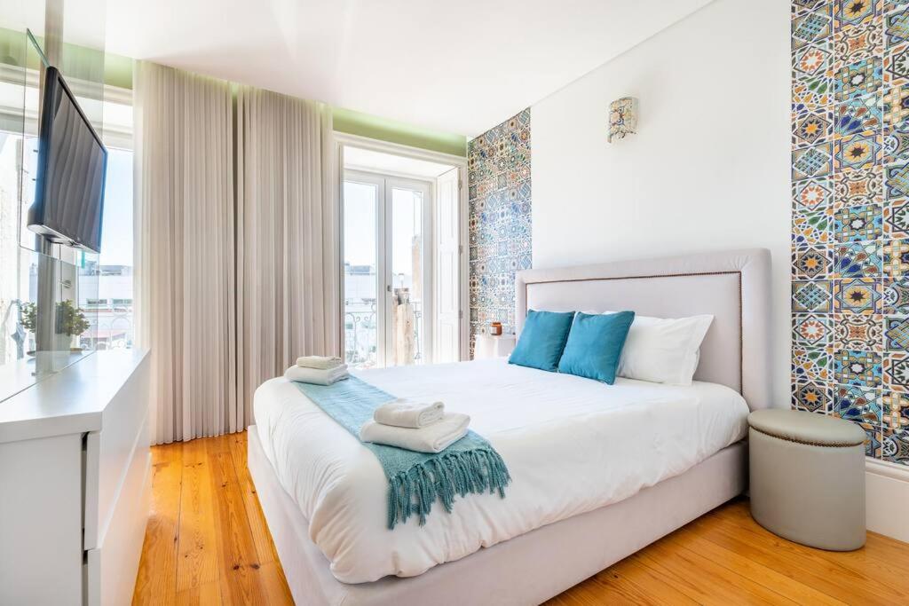 - une chambre avec un grand lit blanc et des oreillers bleus dans l'établissement The Mosaics Studio @ Porto Centre w/ Balcony, à Porto