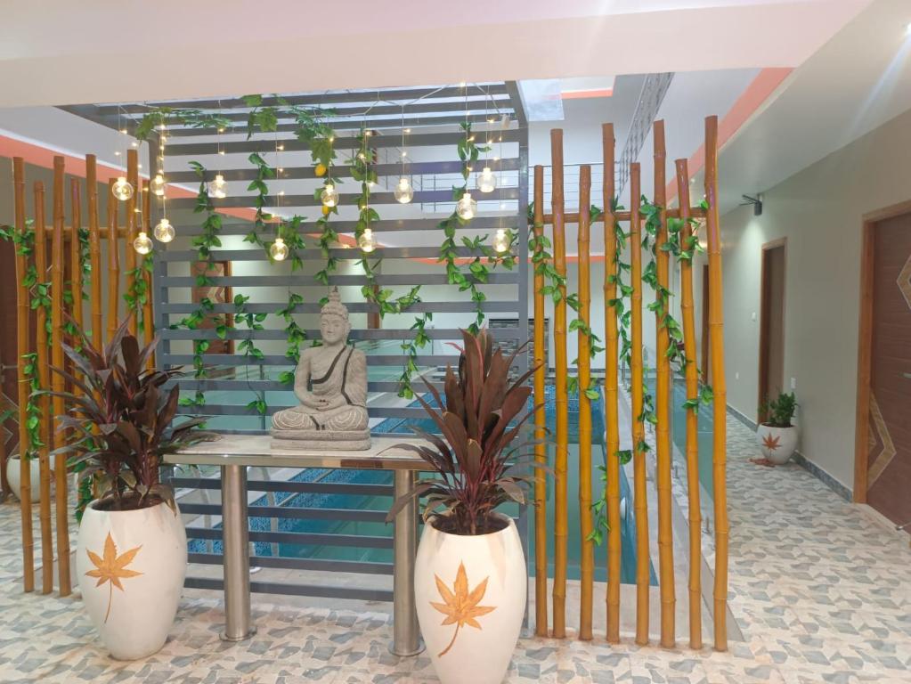 een kamer met een tafel met planten en een standbeeld bij Paradise Breeze Inn in Kottakupam
