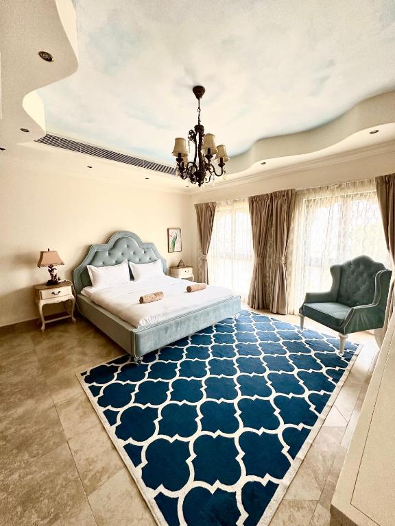 sypialnia z łóżkiem i niebieskim dywanem w obiekcie DARÏ w Dubaju