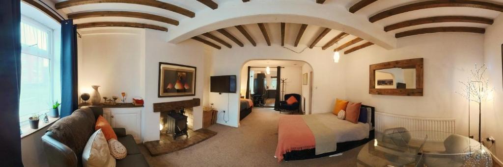 een woonkamer met een bank en een open haard bij King St Cosy - wood stove & ice maker in Loughborough