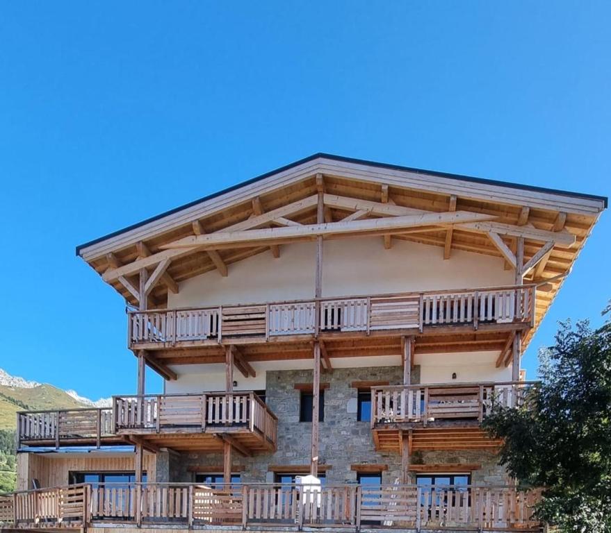 un grand bâtiment avec un balcon en bois dans l'établissement Les Gentianes, à Saint-François-Longchamp