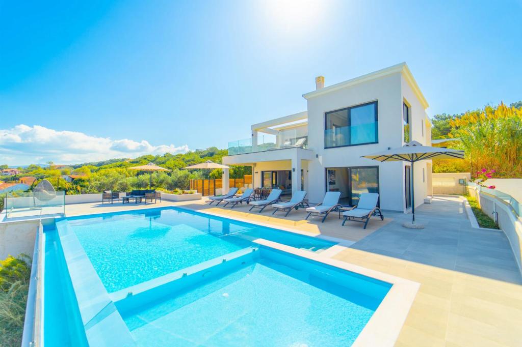 una villa con piscina e una casa di Villa Halcyon ad Agios Stefanos