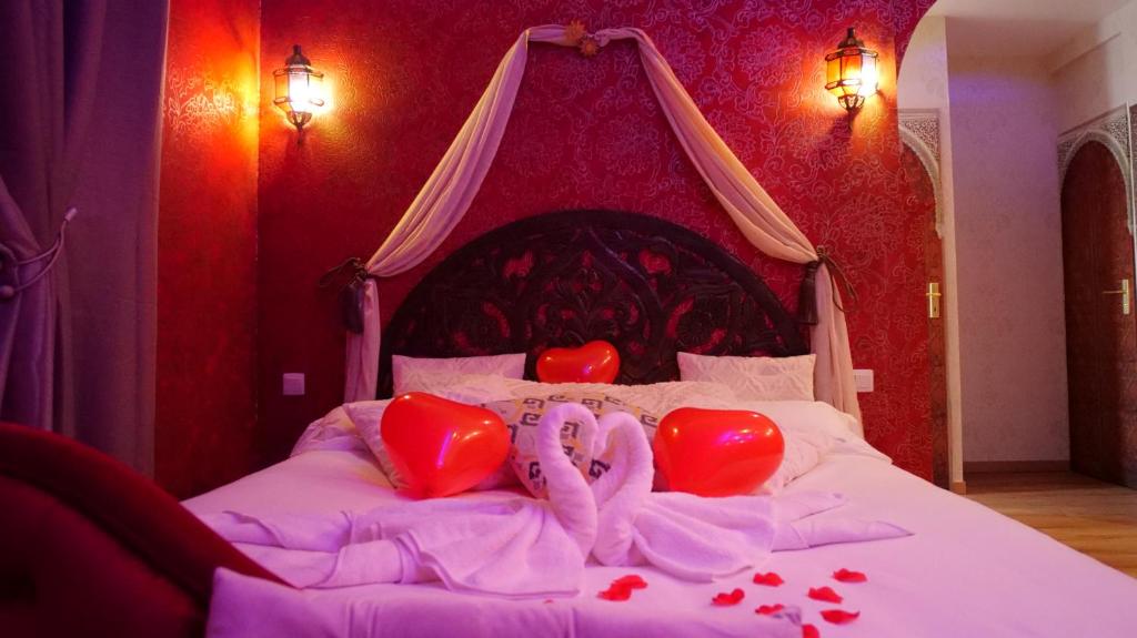 Un dormitorio con una cama con corazones. en Spa Le Rubis d'Orient, en Calais