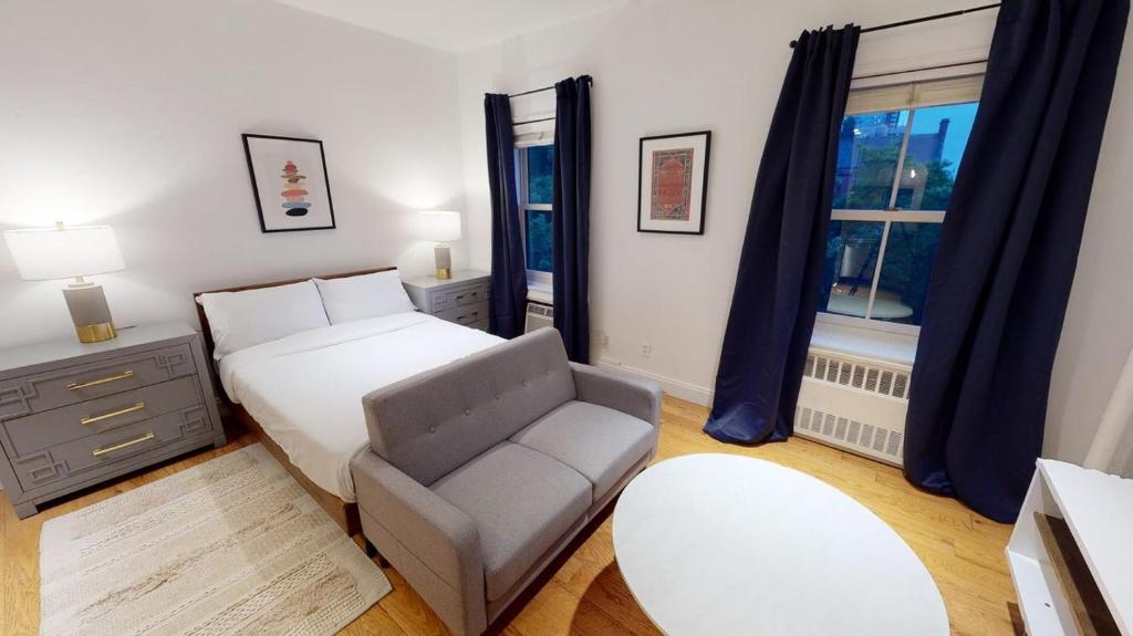 een slaapkamer met een bed, een stoel en een raam bij Apartment 1287: Chelsea in New York