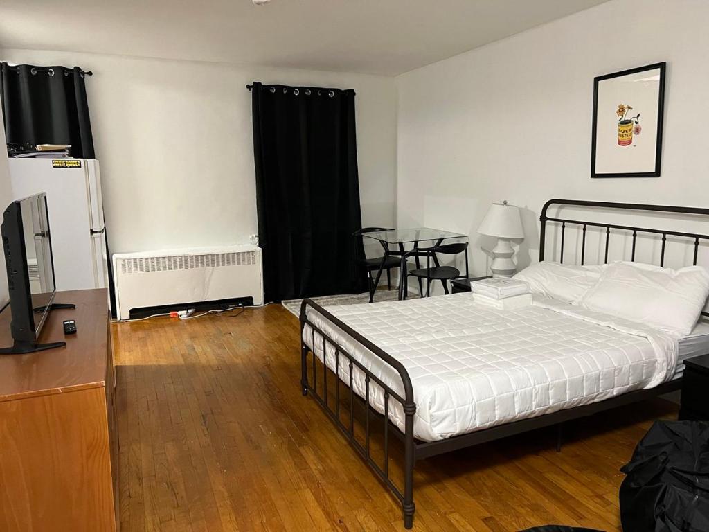 1 dormitorio con 1 cama y 1 mesa con TV en Apartment 1333: East Village, en Nueva York