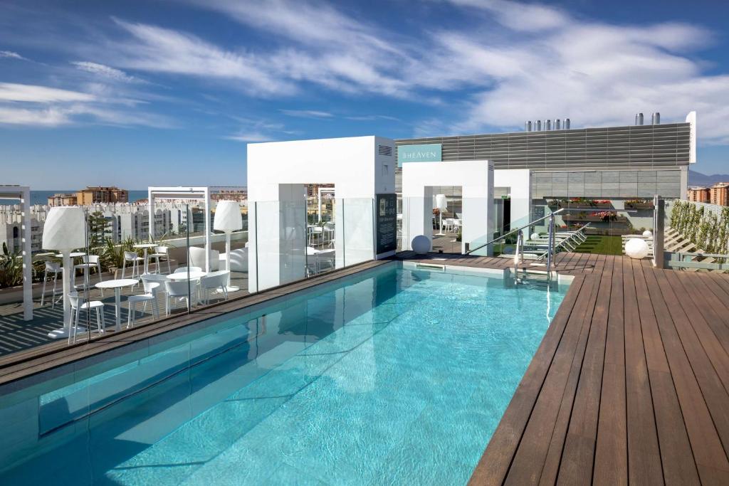 a swimming pool on the roof of a building at Barceló Malaga in Málaga