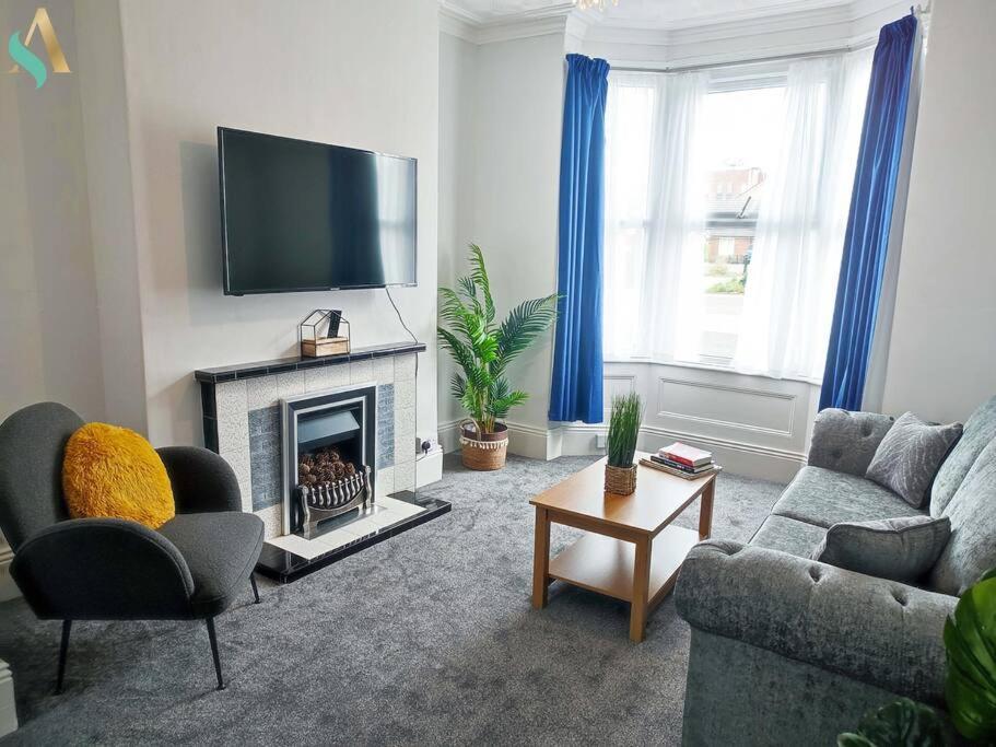 een woonkamer met een bank en een open haard bij St Bernard House TSAC in Stockton-on-Tees