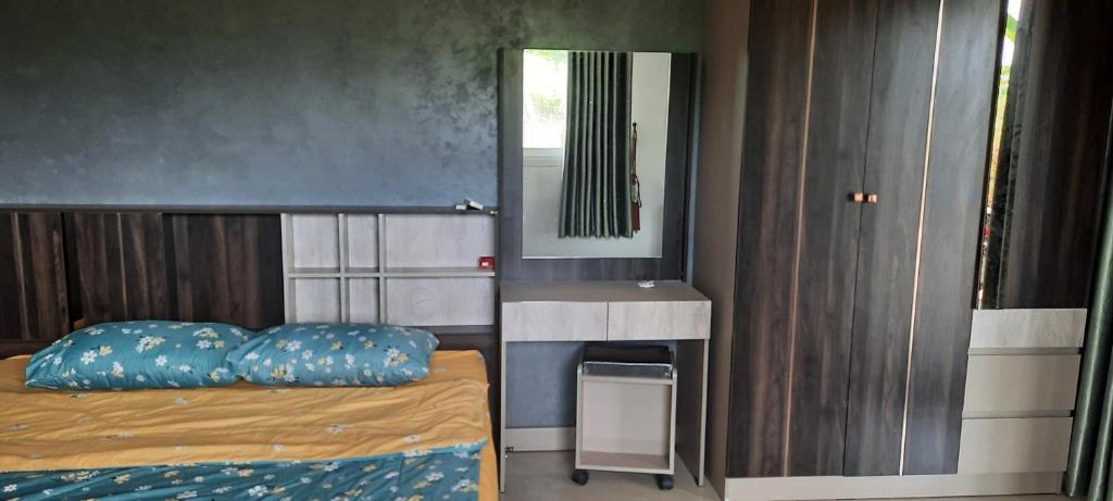 Schlafzimmer mit einem Bett, einem Waschbecken und einem Spiegel in der Unterkunft โฮมสเตย์แม่ปราณี2 
