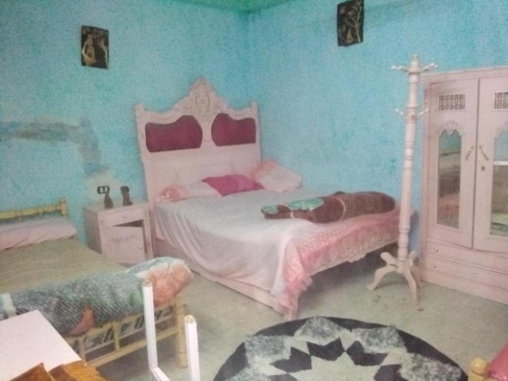 a bedroom with two beds and a cross on the wall at الشاكر للايجار in Minya