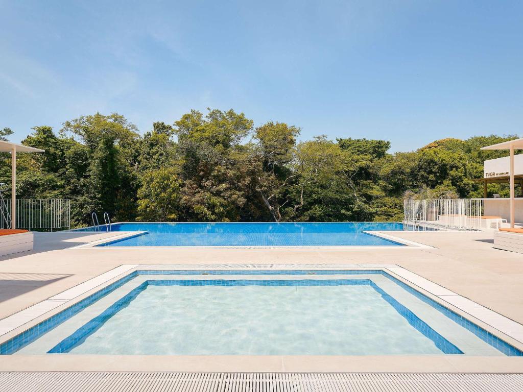 a large swimming pool with blue water at Mercure Ambassador Jeju in Seogwipo