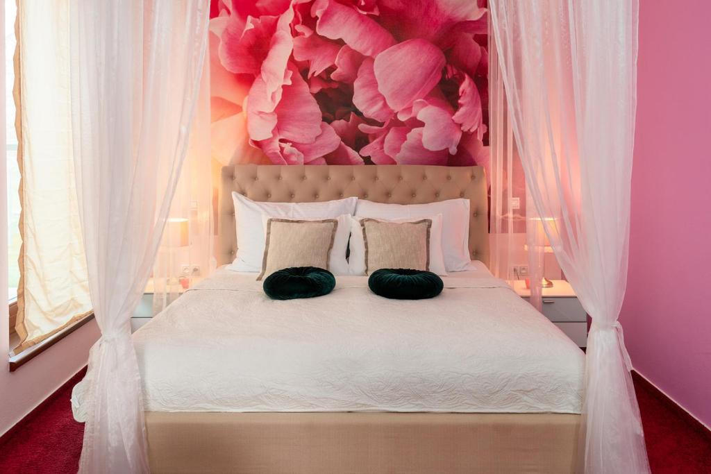 a bedroom with a white bed with a pink wall at Design Hotel Romantick in Třeboň