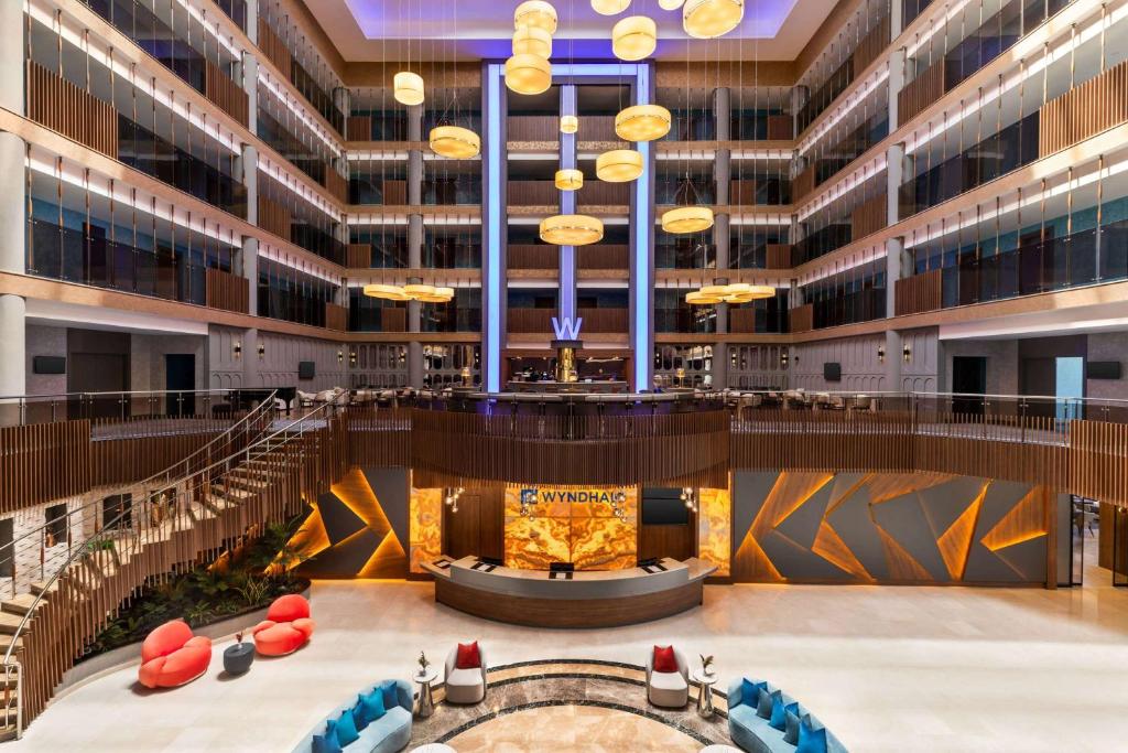 an empty lobby of a large building with tables and chairs at Wyndham Afyonkarahisar Thermal&Spa in Erkmen