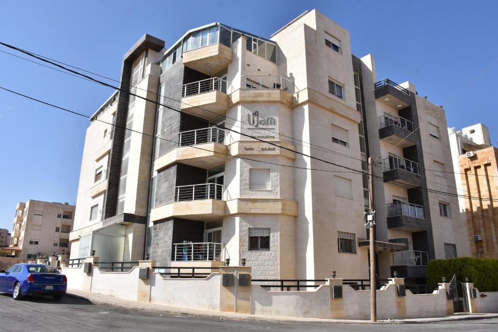 budynek z samochodem zaparkowanym przed nim w obiekcie Lijam Apartments w mieście Amman