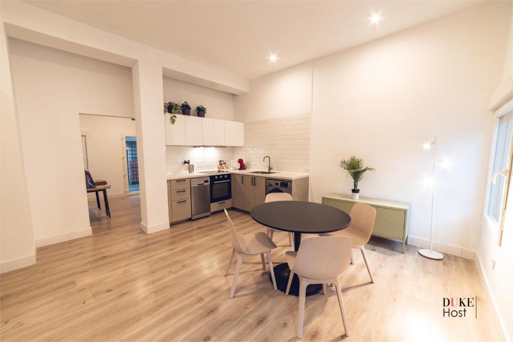 a kitchen and dining room with a table and chairs at 5Torres Apartment in Madrid
