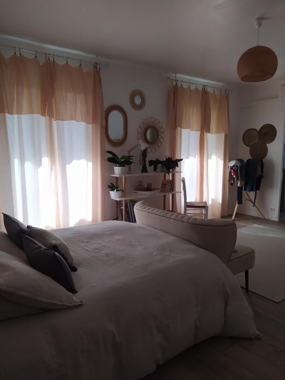 a bedroom with a large white bed and windows at studioleyme in Leyme