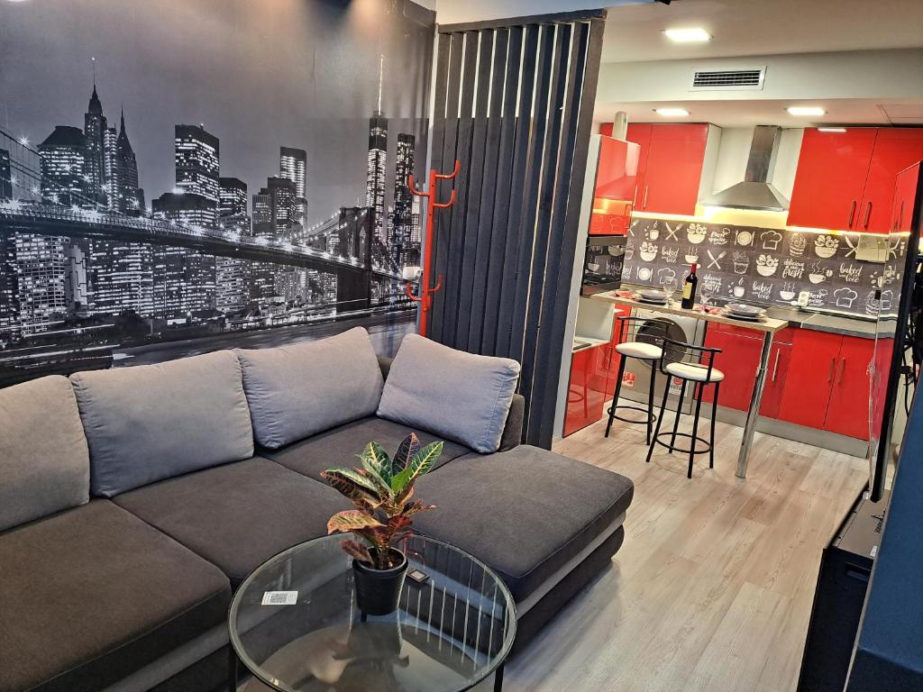 een woonkamer met een bank en een keuken bij Moraleja suite 2 in Alcobendas