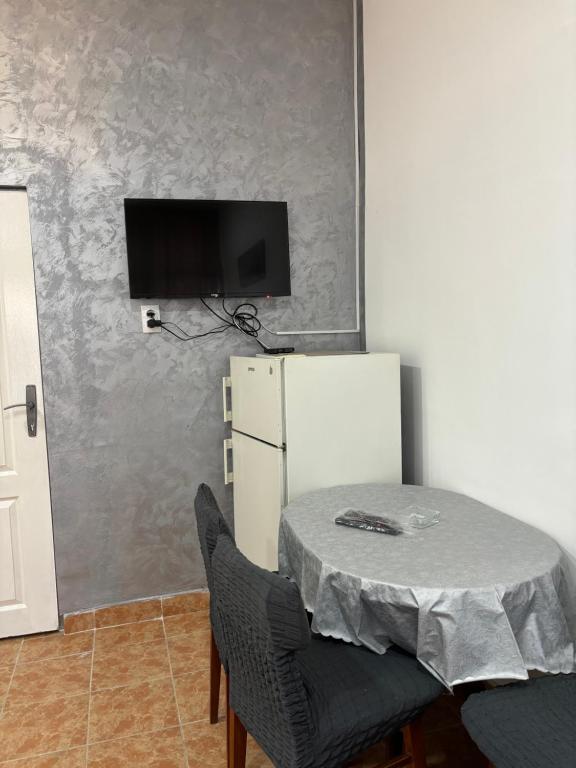 a dining room with a table and a refrigerator at Apartman Stil in Kruševac