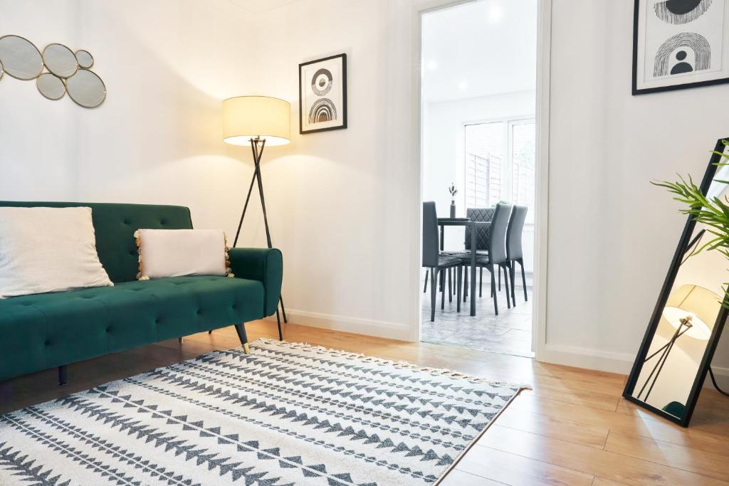 - un salon avec un canapé vert et un tapis dans l'établissement 3 Bedroom Home in Central Milton Keynes, à Loughton