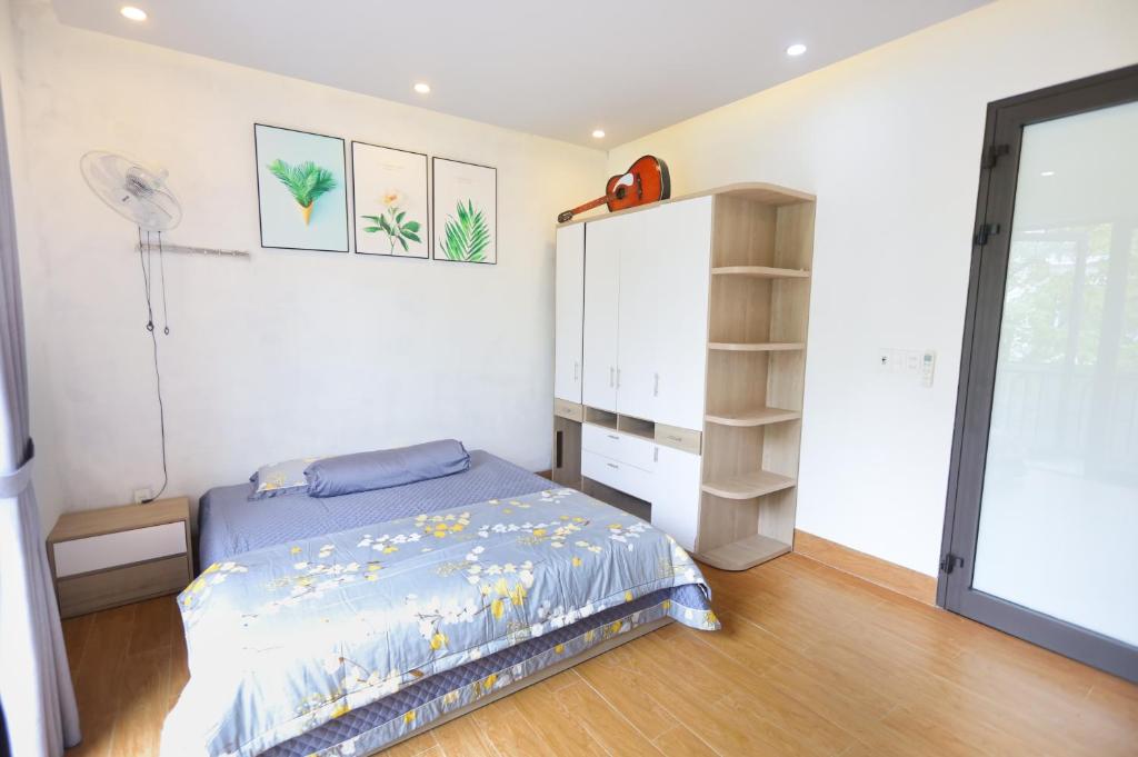 1 dormitorio con 1 cama, armario y ventilador en Nhà riêng có 4 phòng ngủ - Kennpi Aparment en Hue