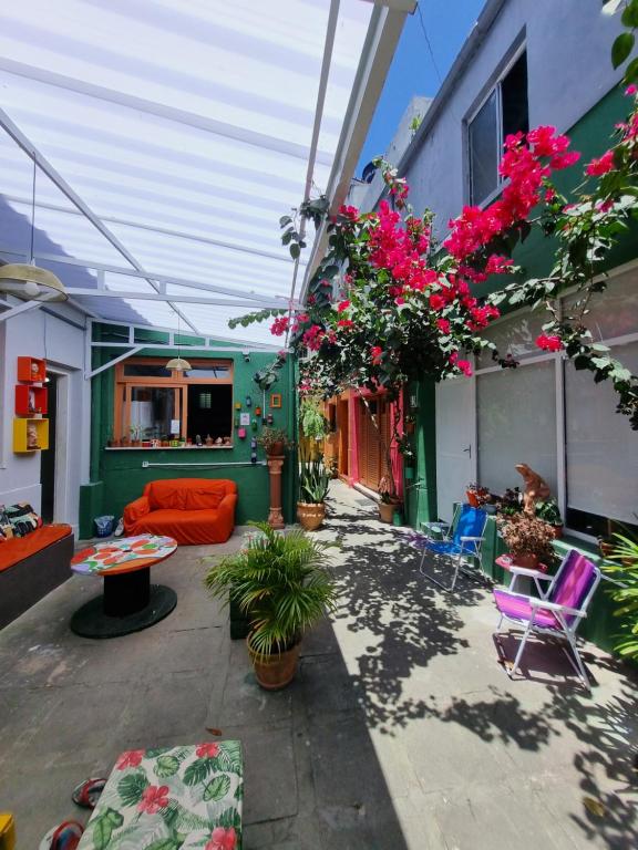 a patio with a couch and chairs and flowers at Nomads Hostel Multicultural & Coworking in Salvador
