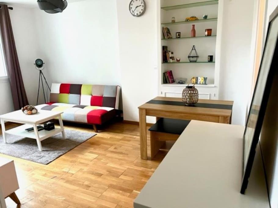 un salon avec un canapé et une table dans l'établissement Charmant appartement 3 pièces, à Paris