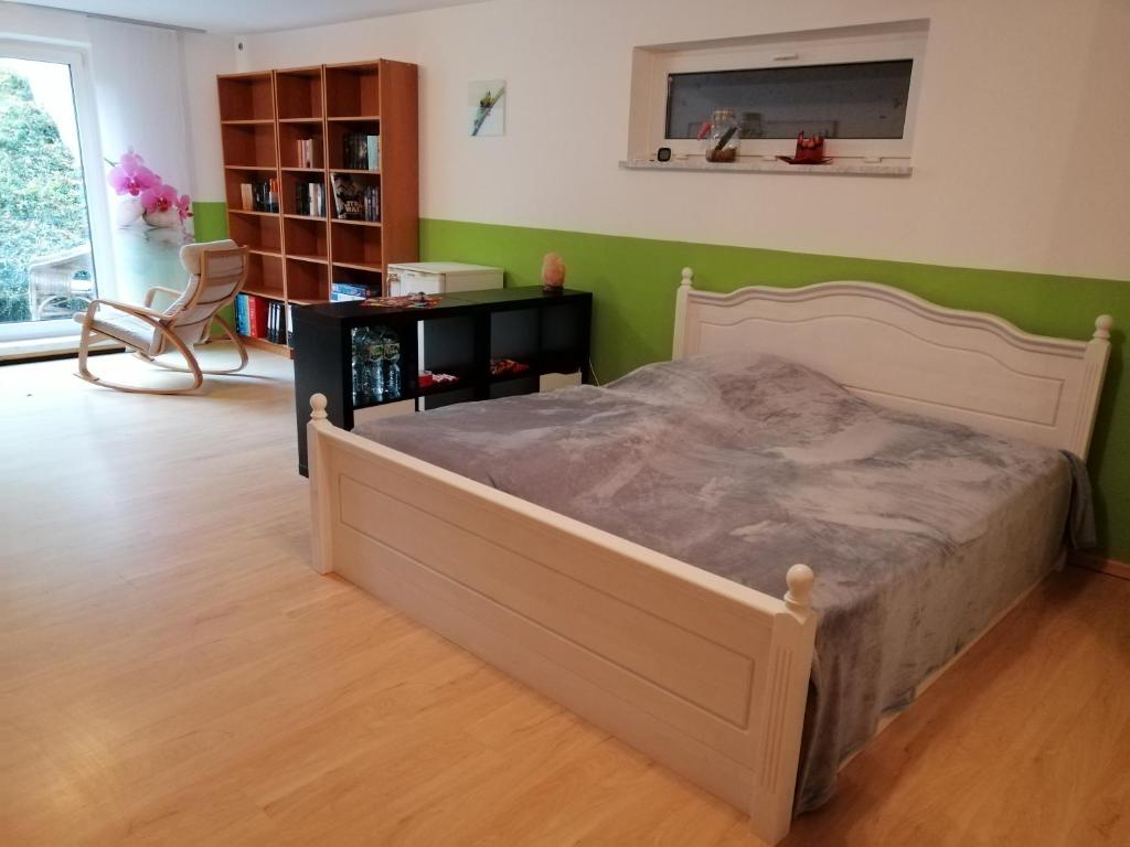 een slaapkamer met een bed en een groene muur bij Ferienwohnung Borger in Sauerlach