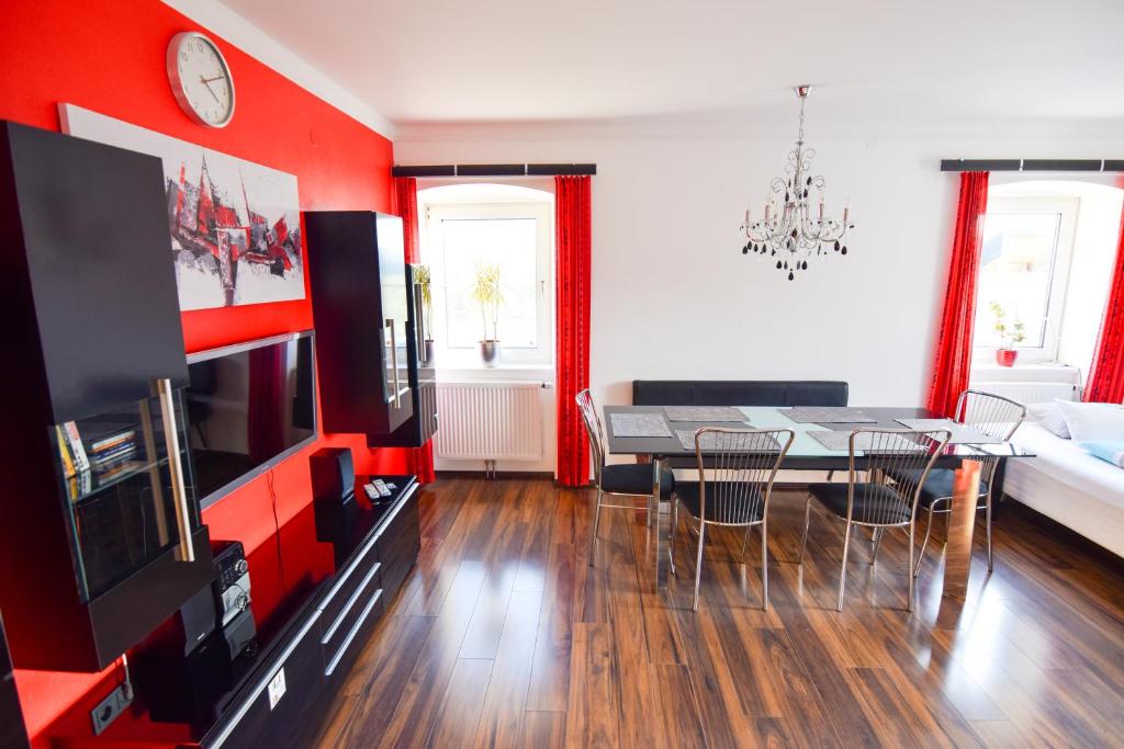 a living room with red walls and a dining room at schöne, vollausgestattete 90m2 Wohnung mit drei Zimmern am Land 