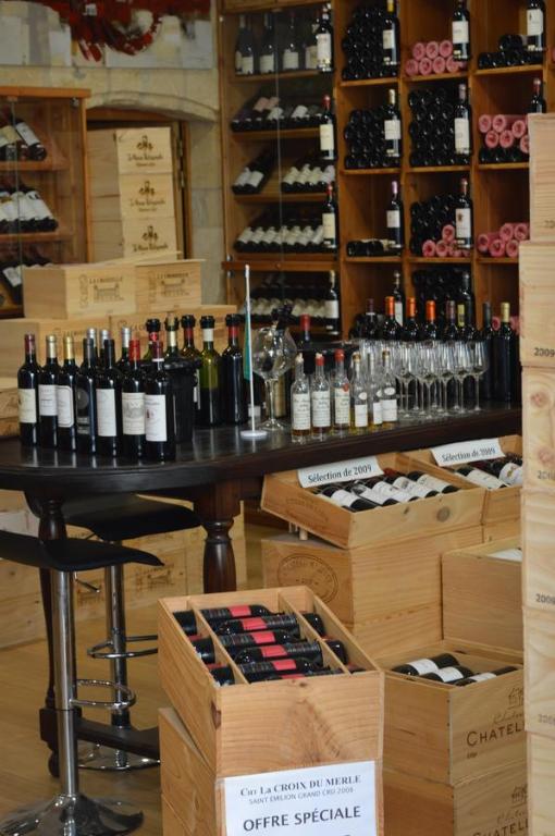 a room with a table with bottles of wine at Logis des Jurats in Saint-Émilion