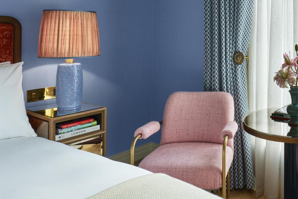 a bedroom with a bed and a chair and a table at Broadwick Soho in London