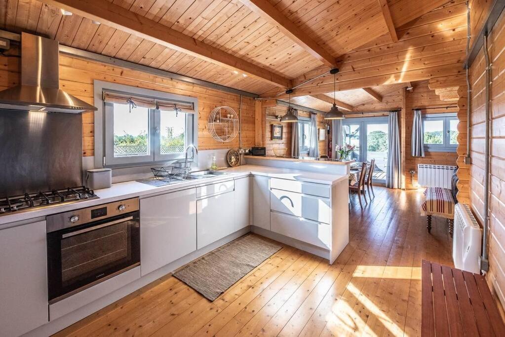 a kitchen with wooden walls and a wooden floor at The Cabin, Parham in Woodbridge