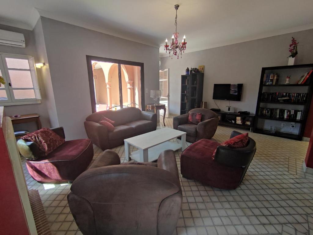 een woonkamer met banken en stoelen bij Chambre Secret Room, Riad 3 Couple only au village naturiste in Cap d'Agde