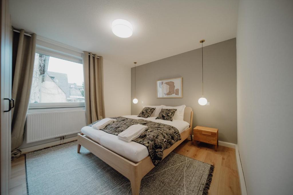 een slaapkamer met een bed en een groot raam bij Koblenz Suites - Design Apartment Koblenz City in Koblenz
