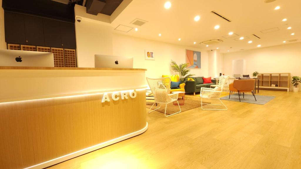 an office lobby with a reception counter and chairs at Acro Capsule Hotel Namba Dotonbori in Osaka