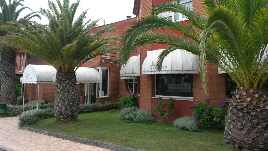 dos palmeras delante de un edificio en Hotel Casa Fernando II, en Rellayo